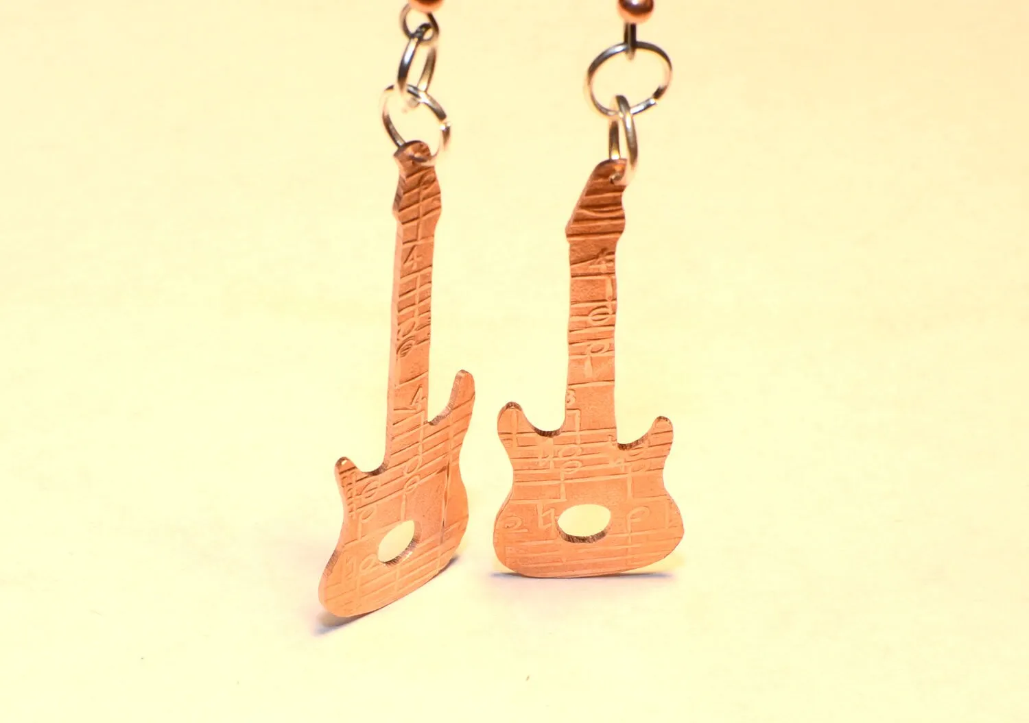 Copper guitar shaped earrings with music notes