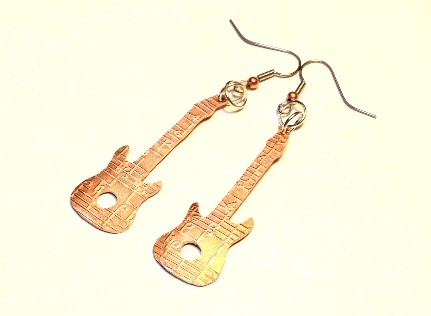 Copper guitar shaped earrings with music notes